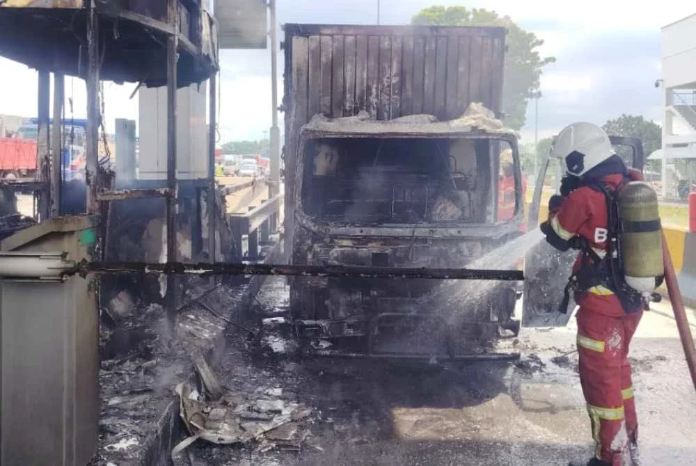 Anggota bomba memadamkan kebakaran melibatkan sebuah lori dan pondok tol di Plaza Tol Sungai Ramal menghala ke Jalan Reko, Kajang pada Selasa.