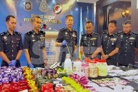 Dennis Lim (tiga dari kiri) menunjukkan dadah bernilai RM9.7 juta.
