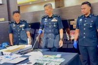 Dennis Lim (tengah) menunjukkan wang tunai yang dirampas dalam 12 tangkapan menerusi Op Soga XI.