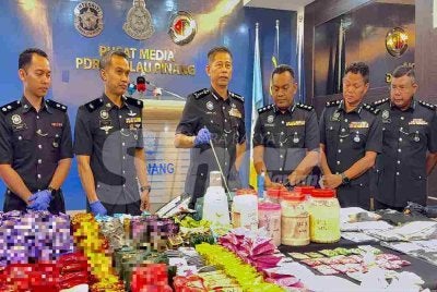 Dennis Lim (tiga dari kiri) menunjukkan dadah bernilai RM9.7 juta.