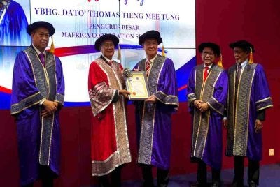 Mohd Fuzi (dua dari kiri) sambil diiringi Rosli (dua dari kanan) menyampaikan sijil pelantikan kepada salah seorang penerima di Auditorium Dato’ Abdul Majid, IKMa pada Selasa.
