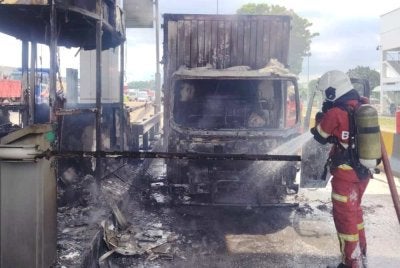 Anggota bomba memadamkan kebakaran melibatkan sebuah lori dan pondok tol di Plaza Tol Sungai Ramal menghala ke Jalan Reko, Kajang pada Selasa.