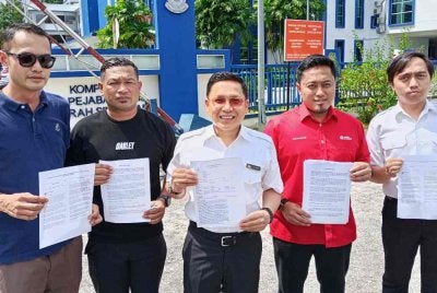 Noor Azleen (tengah) menunjukkan laporan polis yang dibuat di IPD Seri Alam pada Khamis.