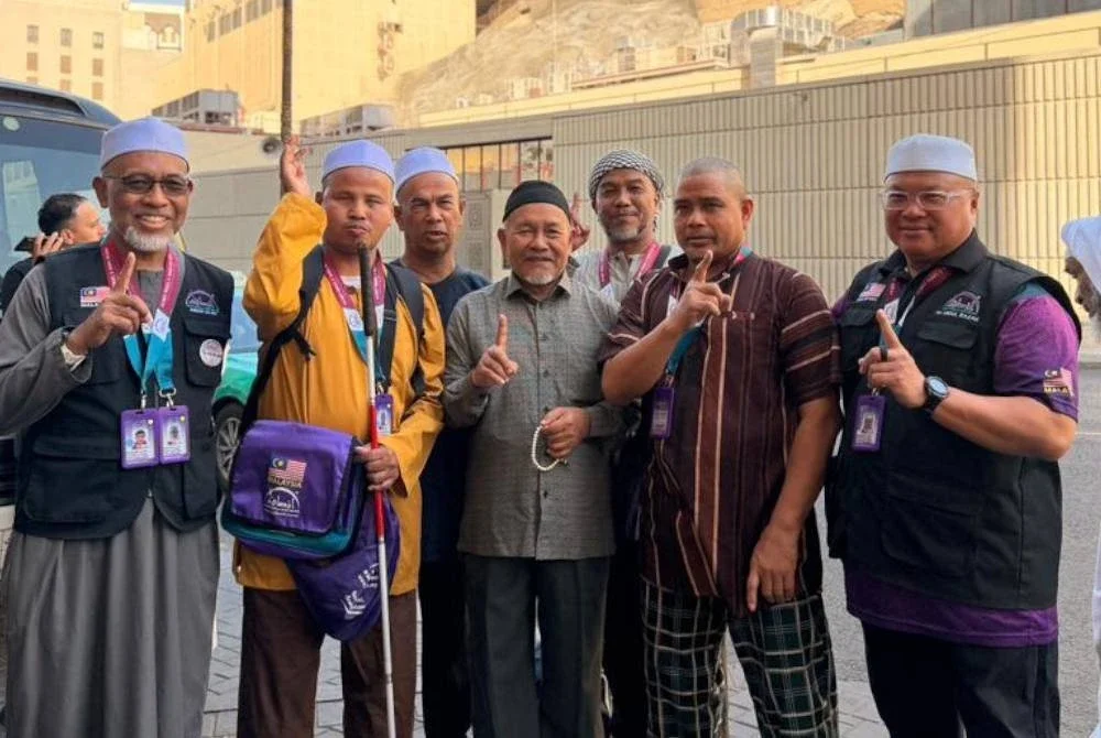 AHMAD NAJMI (kiri) bersama Tuan Ibrahim Tuan Man (tengah) dan jemaah Pertis ketika menunaikan umrah Ramadan lalu. Foto IN SAFF