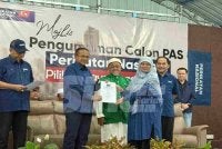 Ahmad Samsuri menyampaikan watikah pelantikan calon Pas kepada Normala Sudirman yang akan bertanding di DUN Tenang.
