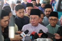Anwar (tengah) bercakap pada sidang media selepas menunaikan solat Jumaat di Masjid Jamiatus Solehah, Pekan Dengkil.