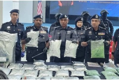 Hussein (dua kiri) menunjukkan dadah yang dirampas.