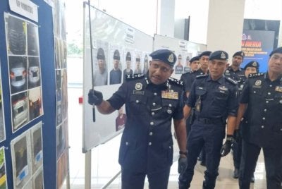Hussein (kiri) menunjukkan aset yang disita.