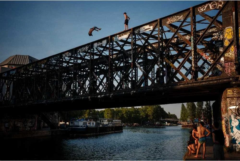 Sekumpulan remaja terjun dari Jambatan Passerelle des Ardennes ke Bassin de la Villette di Paris.