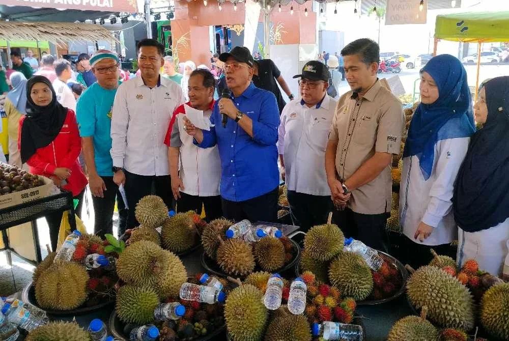 Azleena (dua dari kanan ) menyaksikan jualan kombo durian yang diumumkan Mohd Zolkafly (tengah) sempena Program Jualan Agro Madani Mega @ Pusat Transformasi Luar Bandar (RTC) Perak di Pentas Utama RTC Perak pada Sabtu.
