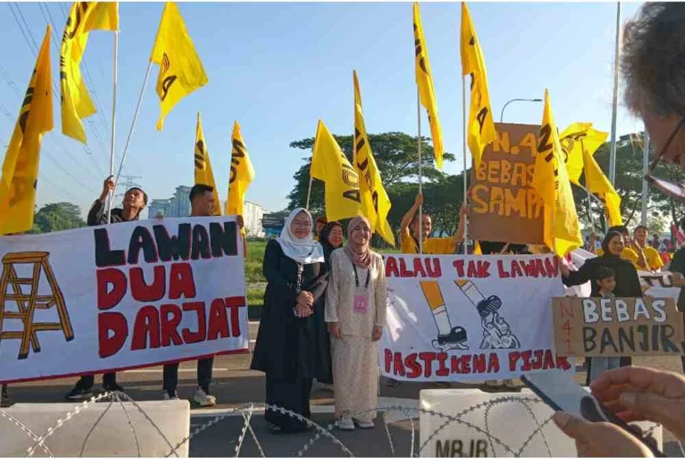 Rashifa (kanan) dan Amira Aisya (kiri) bersama penyokong MUDA.