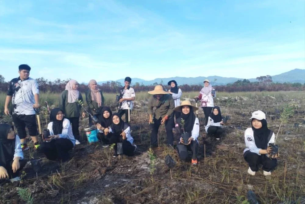 Antara peserta yang terlibat menanam pokok gelam di kawasan seluas 0.81 hektar di Tasik Berombak, Kampung Saujana pada Jumaat.