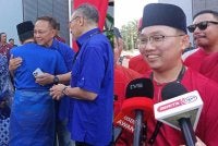 Onn Hafiz memeluk Hasni dan Hishammuddin selepas diumumkan sebagai calon DUN Machap di Dewan Muafakat Majlis Daerah Simpang Renggam pada Sabtu dan Nur Hafiz (Kanan).