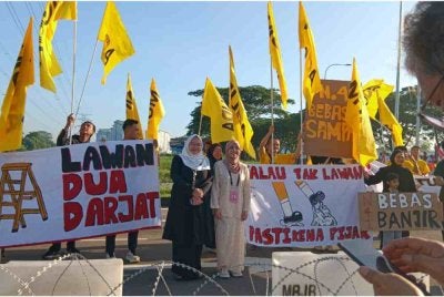 Rashifa (kanan) dan Amira Aisya (kiri) bersama penyokong MUDA.