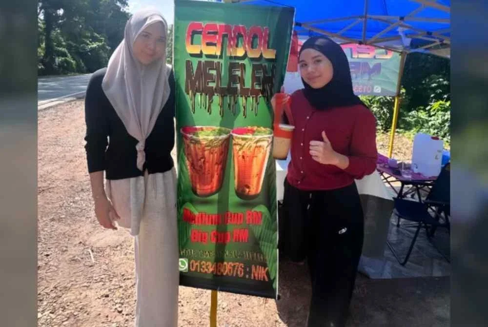 Nik Haznita (kiri) dan adiknya, Nik Haziera gigih menjual cendol di Kampung Seri Lebak walaupun hanya satu kaki. Foto Ihsan Nor Haziera