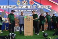 Mohamed Khaled (dua dari kiri) menyerahkan hadiah kepada pemenang cabutan bertuah sempena Karnival Hadi Keluarga Kita bersama warga Angkatan Tentera Malaysia (ATM) Zon Selatan di Kluang pada Ahad.
