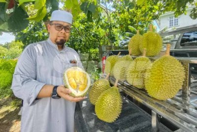 Ahmad Maher menunjukkan buah durian yang dijual. 