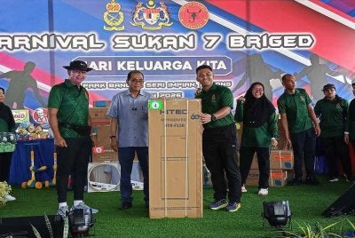 Mohamed Khaled (dua dari kiri) menyerahkan hadiah kepada pemenang cabutan bertuah sempena Karnival Hadi Keluarga Kita bersama warga Angkatan Tentera Malaysia (ATM) Zon Selatan di Kluang pada Ahad.

