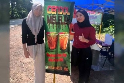Nik Haznita (kiri) dan adiknya, Nik Haziera gigih menjual cendol di Kampung Seri Lebak walaupun hanya satu kaki. Foto Ihsan Nor Haziera