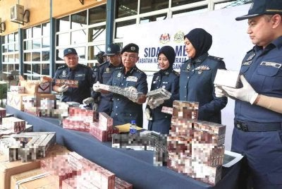 Hasbollah (empat, kanan) menunjukkan antara rokok seludup yang dirampas dalamempat siri serbuan berasingan di sekitar Terengganu dan Kelantan sepanjang April hingga Mei lalu. 