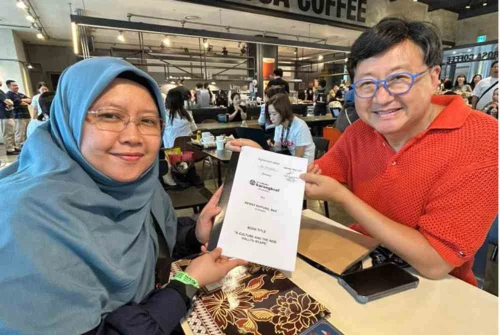 Azzah (kiri) menyerahkan perjanjian penerbitan kepada Dr Kenny pada lawatan delegasi GBK ke SIBF 2026 di COEX, Seoul, Korea Selatan.