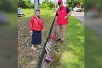 Chu Poh Yee (kiri) menunjukkan bahan kempen yang dirosakkan. - Foto FB Chu Poh Yee