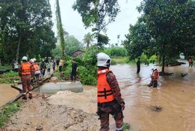 Pasukan penyelamat mengakses kawasan terjejas menggunakan sistem tali keselamatan bagi memastikan keselamatan anggota ketika meredah kawasan yang ditenggelami air. Foto ihsan bomba