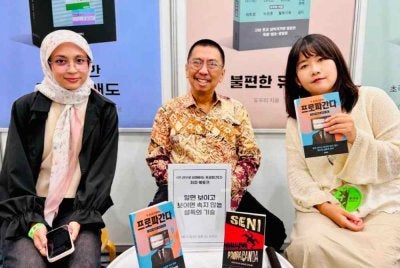 Budiman (tengah) menunjukkan karyanya dilancarkan di Convention and Exhibition Center (COEX), Seoul pada 27 Jun bersempena Pesta Buku Antarabangsa Seoul 2026.