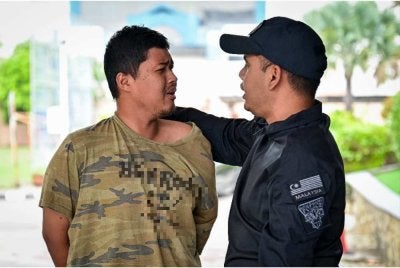 Muhammad Nor Iman (kiri) dituduh mencederakan neneknya menggunakan tukul besi hingga parah. Foto: Bernama
