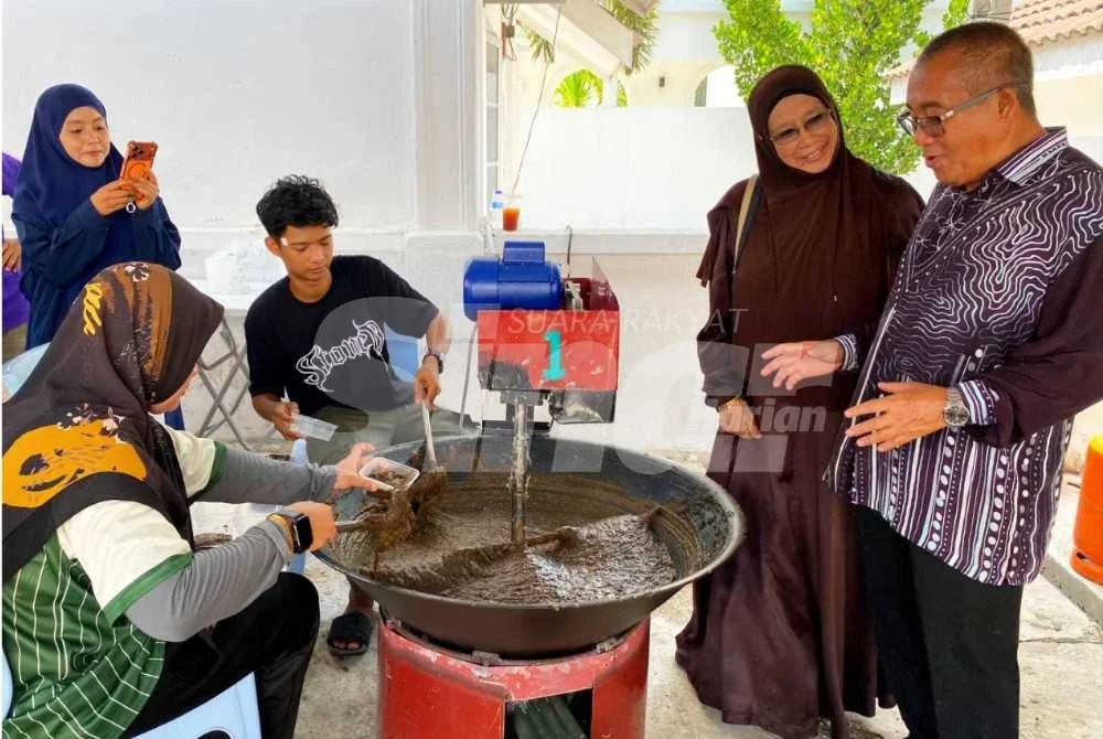 Ibrahim (kanan) turut sama turun padang melihat bagaimana proses pembuatan bubur asyura menggunakan mesin khas yang disewa pada Program Gotong-royong Mengacau Bubur Asyura yang diadakan di Masjid Imanul Faizin, Kota Bharu.
