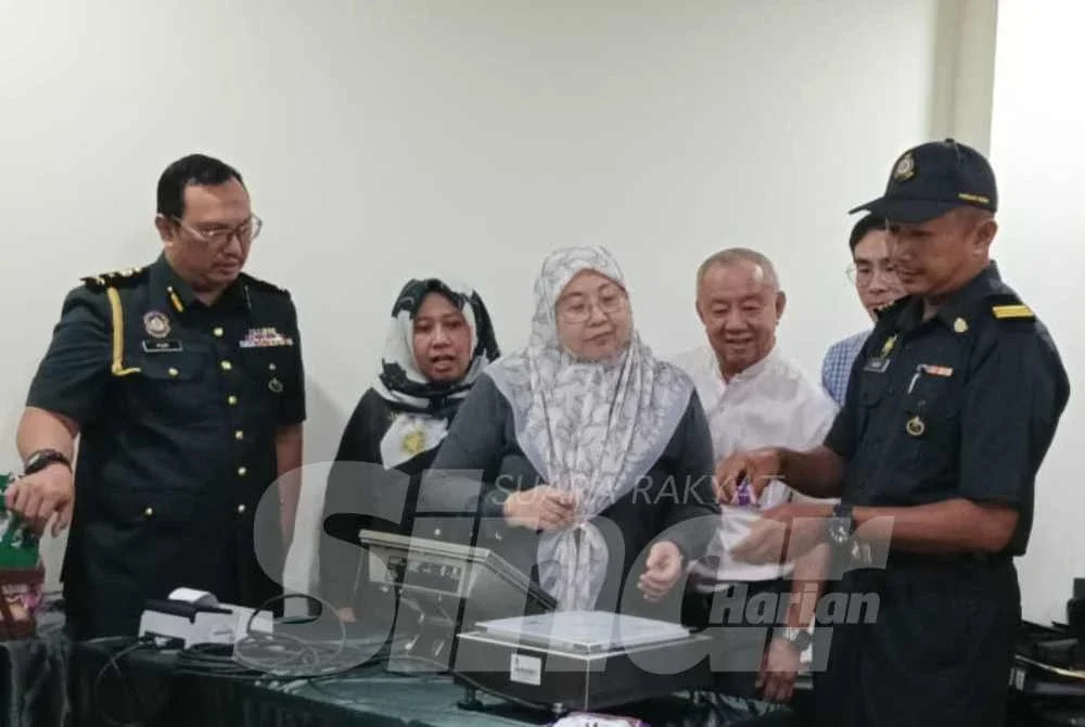 Fuziah (tengah) melihat penguat kuasa KPDN melaksanakan proses menimbang berat produk pada lawatan kerja di Kilang Roti SDS Manufacturing di Bukit Kempas, Johor Bahru pada Selasa.
