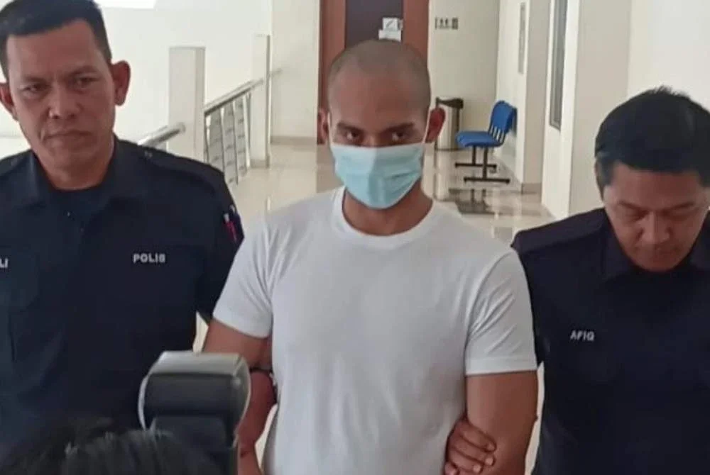 Amirul Amin memakai baju-T putih ketika dibawa keluar dari Mahkamah Tinggi Klang selepas dijatuhi hukuman penjara 32 tahun dan 12 sebatan kerana membunuh kekasihnya dengan menekup muka mangsa menggunakan bantal.