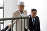 Nurhafizul Badrul (kiri) mengaku tidak bersalah atas tuduhan memuat naik hantaran palsu berkaitan dakwaan penjualan 52 juta liter bahan api kepada Filipina. Foto Bernama