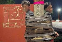 Dua lelaki diikat pada sebatang tiang lampu dengan mulut mereka ditampal pita pelekat oleh individu yang dipercayai bertindak sebagai 'hero' yang tidak dikenali di Jalisco. Foto The Telegraphy