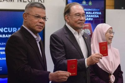 Anwar (tengah) melancarkan Pasport Malaysia Antarabangsa (PMA) versi baharu yang dilengkapi dengan 94 ciri keselamatan di Lobi Parlimen. Foto Bernama