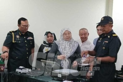 Fuziah (tengah) melihat penguat kuasa KPDN melaksanakan proses menimbang berat produk pada lawatan kerja di Kilang Roti SDS Manufacturing di Bukit Kempas, Johor Bahru pada Selasa.