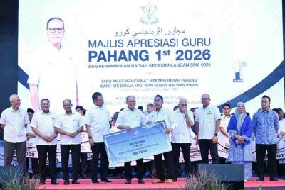 Wan Rosdy (depan, lima dari kiri) menyampaikan anugerah kepada salah seorang penerima sempena Majlis Apresiasi Guru Pahang 1st 2026 dan Penyampaian Hadiah Kecemerlangan SPM 2025 Peringkat Negeri Pahang di Dewan Jubli Perak Sultan Haji Ahmad Shah, Kuantan pada Selasa. Foto: FB Wan Rosdy Wan Ismail