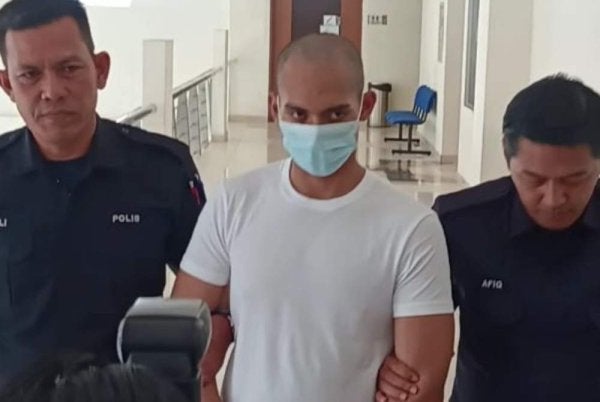 Amirul Amin memakai baju-T putih ketika dibawa keluar dari Mahkamah Tinggi Klang selepas dijatuhi hukuman penjara 32 tahun dan 12 sebatan kerana membunuh kekasihnya dengan menekup muka mangsa menggunakan bantal.