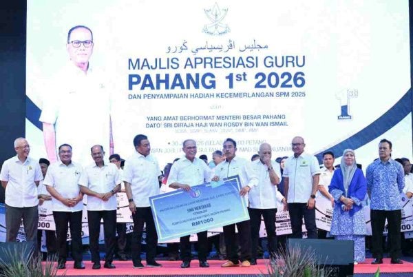 Wan Rosdy (depan, lima dari kiri) menyampaikan anugerah kepada salah seorang penerima sempena Majlis Apresiasi Guru Pahang 1st 2026 dan Penyampaian Hadiah Kecemerlangan SPM 2025 Peringkat Negeri Pahang di Dewan Jubli Perak Sultan Haji Ahmad Shah, Kuantan pada Selasa. Foto: FB Wan Rosdy Wan Ismail