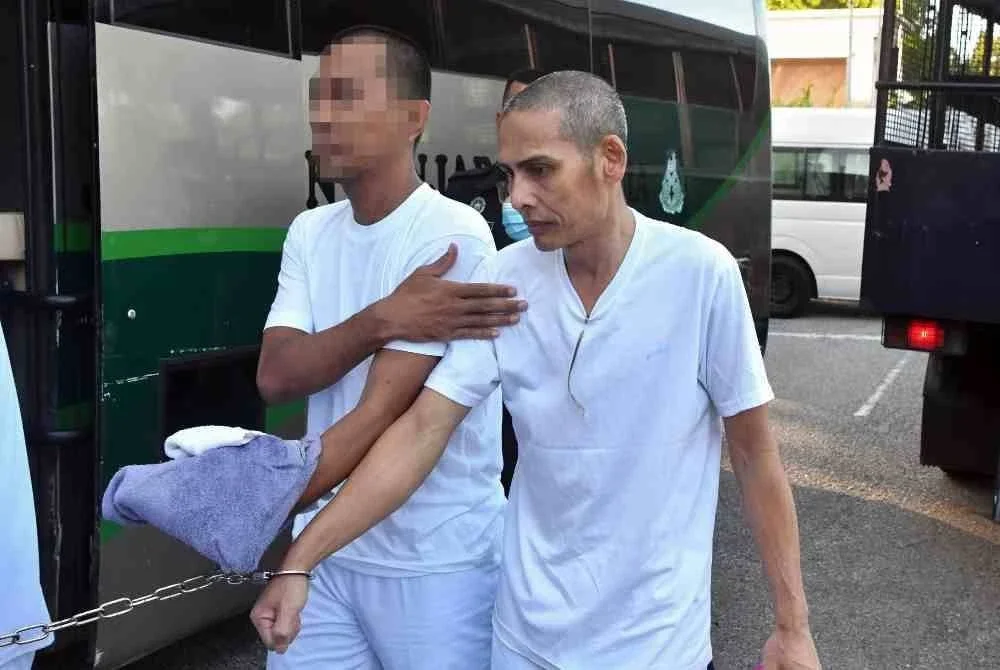 Buruh Amran Salleh, 53, (kanan) dilepas dan dibebaskan oleh Mahkamah Tinggi di sini hari ini atas dua pertuduhan mengedar dadah berbahaya jenis methamphetamine seberat 39,367.27 gram (g), pada Jun 2021. Foto Bernama.