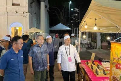 Ahmad Samsuri (dua dari kiri) bersama Dominic (kiri) dan Anuar (kanan) ketika bertemu penduduk DUN Maharani di Bandar Maharani, Muar pada Rabu.