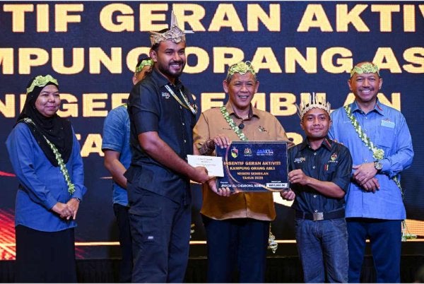 Aminuddin (dua dari kiri) menyampaikan Insentif Geran Aktiviti Kampung Orang Asli kepada Jawatankuasa Pengurusan dan Pembangunan Kampung Orang Asli (JPPKOA) Ulu Chembong, Helmi Naim Ahmad (kiri) pada majlis penyerahan Insentif Geran Aktiviti Kampung Orang Asli Negeri Sembilan di sebuah hotel, hari ini. - Foto: Bernama