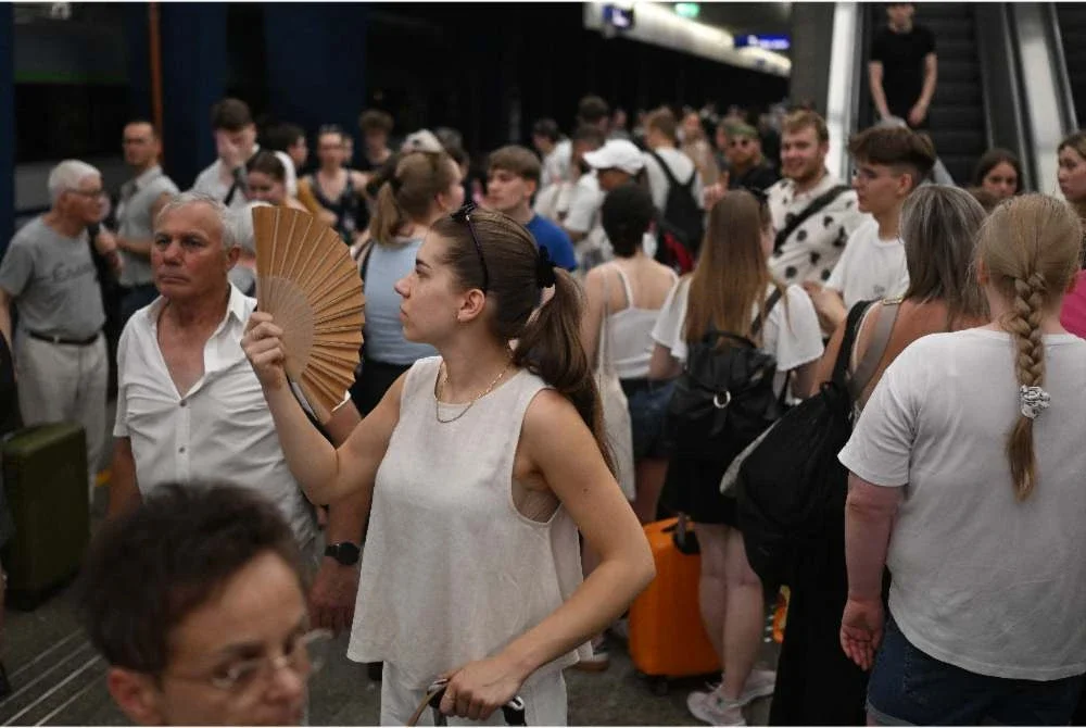 Seorang wanita menggunakan kipas tangan ketika menunggu kereta api yang mengalami kelewatan di Stesen Kereta Api Pusat Warsaw susulan gelombang haba yang menyaksikan suhu di Poland mencecah rekod 40.5 darjah Celsius.