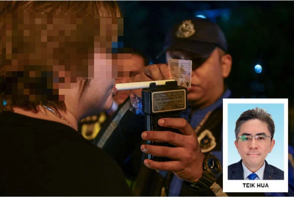 Seorang pemandu sedang menjalankan ujian pernafasan alkohol menerusi sekatan jalan raya. Foto: Bernama