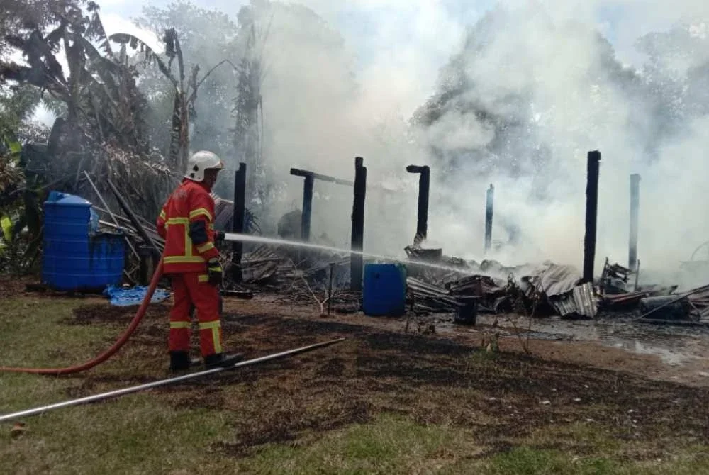 Anggota bomba memadamkan kebakaran melibatkan sebuah rumah dua tingkat di Kampung Bayu Permai, Beluran.