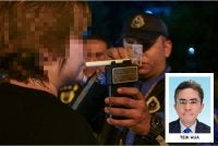 Seorang pemandu sedang menjalankan ujian pernafasan alkohol menerusi sekatan jalan raya. Foto: Bernama