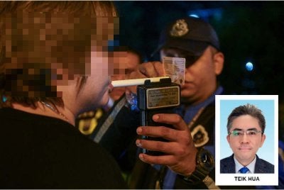 Seorang pemandu sedang menjalankan ujian pernafasan alkohol menerusi sekatan jalan raya. Foto: Bernama