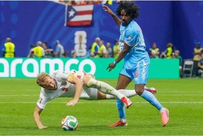 Moutoussamy (kanan) mengekang pergerakan penyerang England, Harry Kane. Foto: Agensi