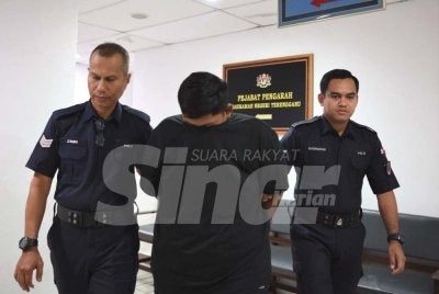 Tertuduh (tengah) dihadapkan di Mahkamah Sesyen Kuala Terengganu pada Khamis.