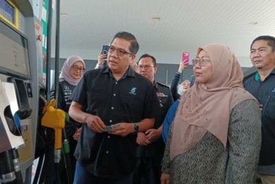 Fuziah (kanan) melihat proses pengisian bantuan subsidi Budi Madani Diesel di Stesen Minyak Petronas Bandar Dato Onn pada Khamis.